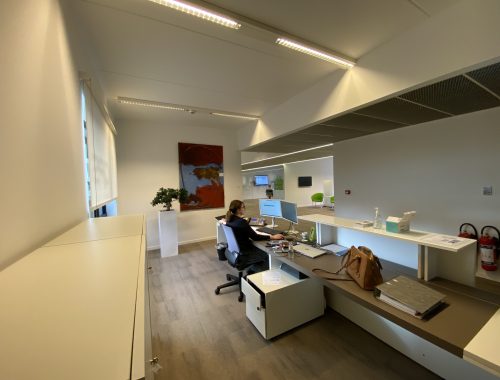 Een kantoorruimte met een zwevende bureau constructie van hout