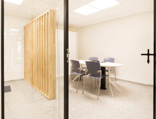 Een kantoorruimte met glazen ramen en deur en houten afscheiding